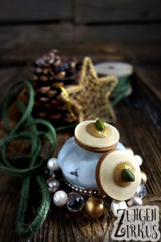 a small white vase sitting on top of a wooden table next to a pine cone