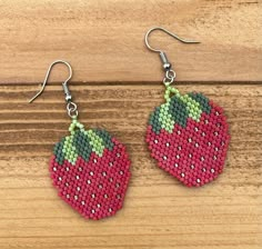 the beaded strawberry earrings are hanging from hooks