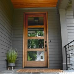 a wooden door on the side of a gray house