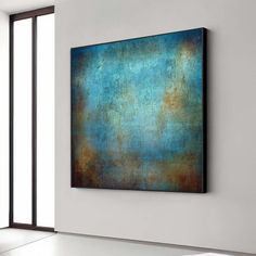 an abstract painting hangs on the wall in a room with white walls and flooring