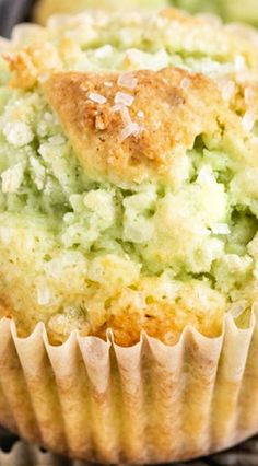 a close up of a muffin in a paper cupcake liner on a table