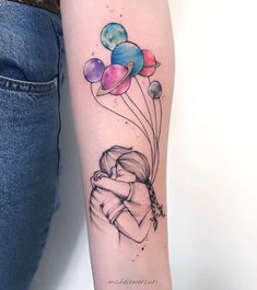 a woman's arm with tattoos on it and some balloons in the shape of planets