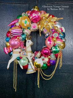 a christmas ornament wreath hanging on a door with ornaments around it and a horse in the center