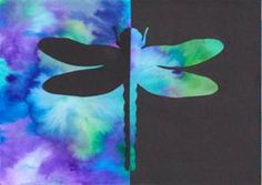 the dragonfly is sitting on top of the black paper with blue and green colors