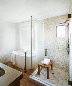 a white bath tub sitting next to a walk in shower