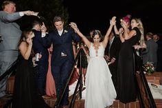 a bride and groom walk down the stairs at their wedding reception with confetti thrown in the air