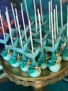 there are many little blue birds on the cake plate with toothpicks in them