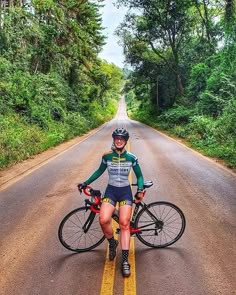 a woman is standing with her bike on the road