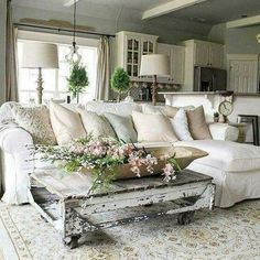 a living room filled with lots of furniture and flowers on top of a coffee table