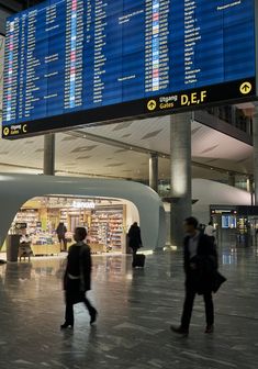 people are walking through an airport terminal