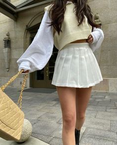 a woman walking down the street carrying a purse