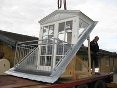 a man standing on the back of a flatbed truck with an upside down window