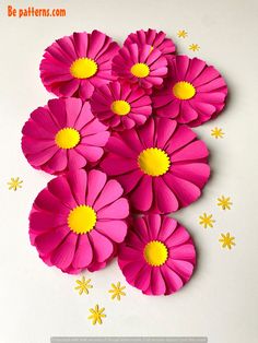 pink paper flowers with yellow centers on a white background