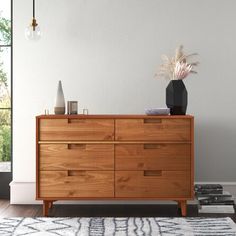 a large wooden dresser sitting on top of a hard wood floor next to a window