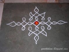 an artistic drawing on the ground with white paint and a red dot in the middle