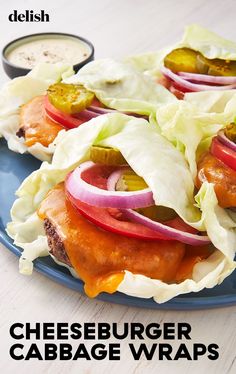 a blue plate topped with meat covered in lettuce and tomatoes