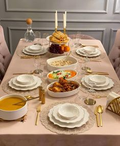 a table set with plates, bowls and silverware