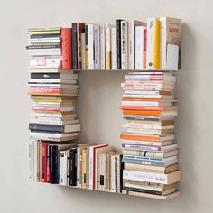 a bookshelf filled with lots of books sitting on top of a wall