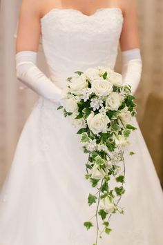 a bride holding a bouquet of white flowers