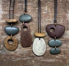 several different types of necklaces hanging on a wooden surface