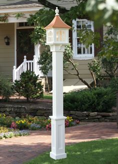 a white lamp post in front of a house