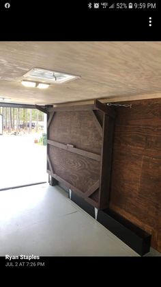 the inside of a garage with wood paneling and sliding glass doors that are open