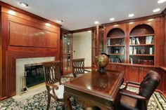 an office with wood paneling and leather chairs in front of a fire place on the wall