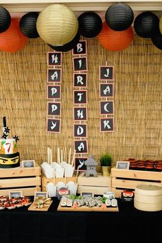 a table topped with lots of food next to black and white decorations on top of a wall