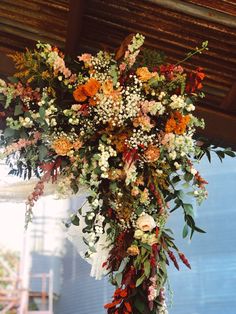 an arrangement of flowers hanging from the ceiling