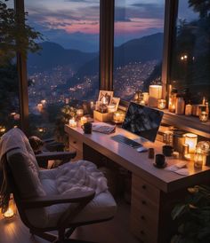 a desk with a laptop on it in front of a window filled with lit candles