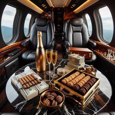 the interior of an airplane with champagne, chocolates and cookies on a round table