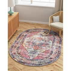 a round rug with an ornate design on the floor next to a chair and window