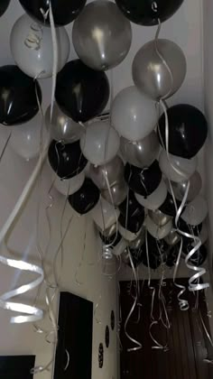 black and white balloons are hanging from the ceiling