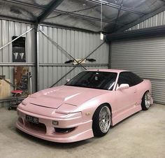 a pink sports car parked in a garage