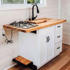 a kitchen island with two burners and a sink in the center is made out of wood