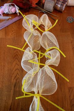 some yellow ribbons and thread on a wooden table