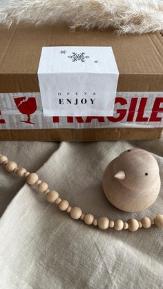 a wooden bead necklace next to an unopened box