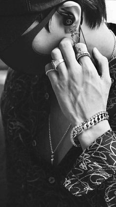 black and white photograph of a woman wearing jewelry on her cell phone