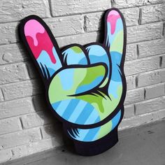 a hand sign painted on the side of a brick wall