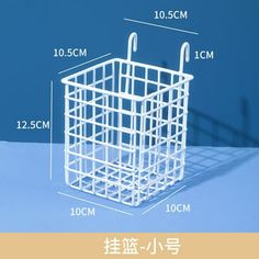 a white wire basket with hooks on it and measurements for the handles to each side