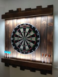 a dart board mounted to the side of a wall with darts in front of it