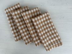 three brown and white checkered napkins sitting on top of a table