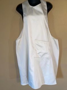 a white apron is hanging on a black mannequin