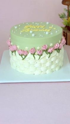 a green cake with pink flowers on top