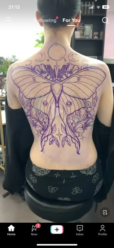 the back of a woman's body with tattoos on her chest and an image of a butterfly