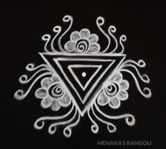 a white drawing on a black surface with an intricate design in the shape of a triangle