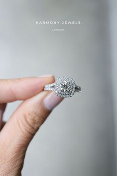 a woman's hand holding a diamond ring with the words harmony jewels on it