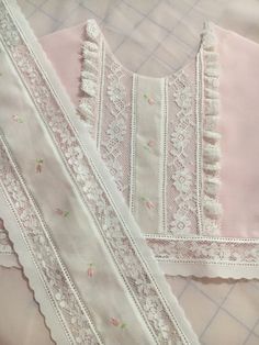 two pieces of pink and white clothing laying on top of each other with lace trims