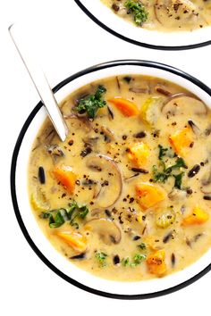 two bowls of soup with mushrooms, carrots and broccoli in it on a white background