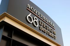 the sign for scottsdale design district is on the side of a building that has been painted gold and black